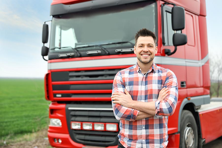 Business Insurance - Truck Driver Standing in Front of a Red Truck Parked by a Corn Field